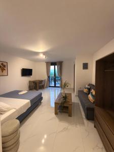 a living room with a bed and a couch at Royal Vinea Suites in Elevtheraí