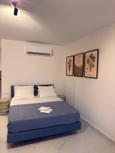 a bedroom with a bed with a blue blanket at Royal Vinea Suites in Elevtheraí