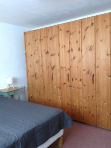 a bedroom with a bed and a wooden wall at Terassenwohnung in Starzach