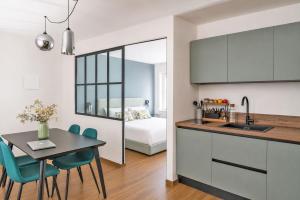 a kitchen and dining room with a table and a bed at Casa Botanica - Boutique Apartment nel centro di Alba in Alba