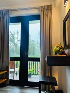 a room with a door with a view of a balcony at The Urban Hideout in Nuwara Eliya