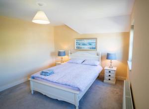 a bedroom with a white bed and two lamps at Old Rectory House - Waterville in Waterville