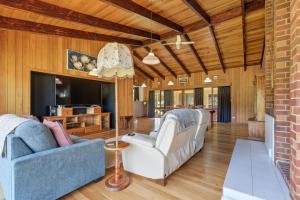 a living room with two chairs and a brick wall at Wildlife, Waves Getaway in Acton Park