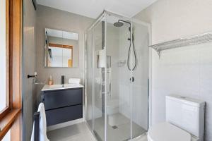 a bathroom with a shower and a toilet and a sink at Wildlife, Waves Getaway in Acton Park +42 photos