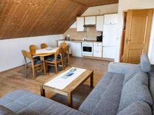 a living room with a couch and a table and a kitchen at Urlaub mit Hund auf dem Bauernhof Hofswald in Euscheid