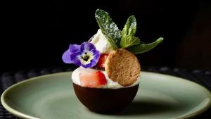 a dessert with fruit and a flower on a plate at La Villa Saint-Antoine in Violès
