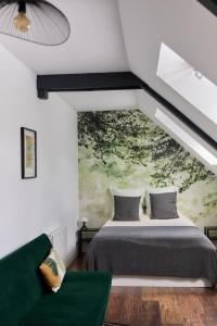 a bedroom with a bed and a green couch at La Breizhidence in Combourg