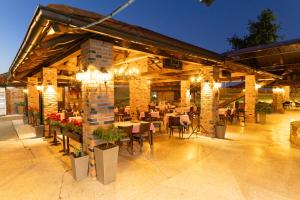 a restaurant with tables and chairs and lights at Motel Stari Hrast in Markovac