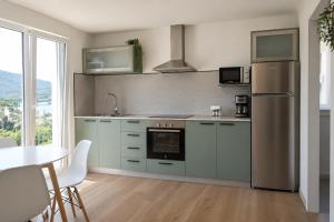 a kitchen with stainless steel appliances and a table at Casa Candola in Noya