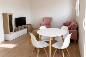 a living room with a table and chairs and a tv at Casa Candola in Noya
