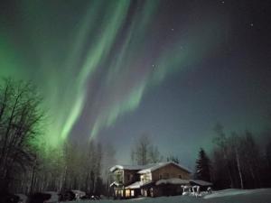 an image of the aurora in the sky over a house at Cozy Christmas Cabin in North Pole