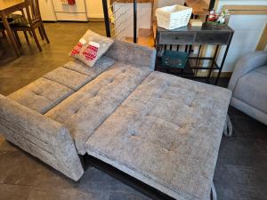 a couch with two pillows on it in a living room at Cozy Christmas Cabin in North Pole