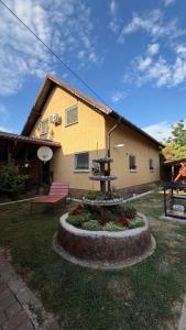 a house with a bench and a fountain in the yard at Ріточка in Berehove