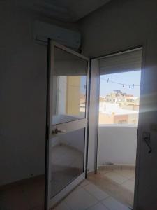 an empty room with a glass door and a window at Appartement Sousse in Hammam Sousse