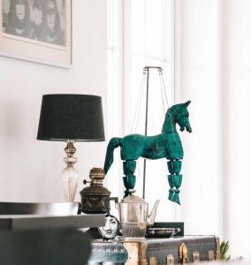 a green toy horse on a table next to a lamp at Secluded Vineyard Villa With Panoramic Views in Kojsko