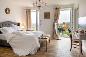 a bedroom with a bed and a man sitting in a table at Secluded Vineyard Villa With Panoramic Views in Kojsko +40 photos
