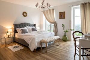 a bedroom with a large bed and a chandelier at Secluded Vineyard Villa With Panoramic Views in Kojsko
