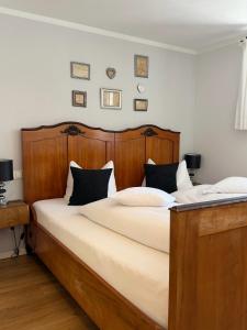 a bedroom with a large bed with a wooden headboard at ChiemseeLeben in Breitbrunn am Chiemsee
