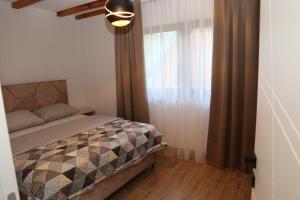 a bedroom with a bed and a window at GUZIJAN seosko domaćinstvo in Šipovo