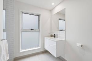 a white bathroom with a sink and a window at Stylish Rosetta Waterview Stay in Rosetta +30 photos