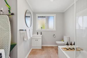 a bathroom with a toilet and a sink and a mirror at Cosy Unit Near MONA in Claremont