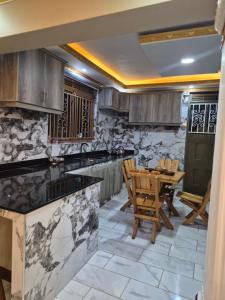 a kitchen with wooden cabinets and a table and chairs at Dinah villas ug in Entebbe
