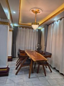 a dining room with a wooden table and chairs at Dinah villas ug in Entebbe