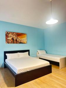 two beds in a room with blue walls at Venice Night B13 in Mestre +39 photos