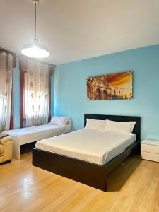 a bedroom with two beds and a blue wall at Venice Night B13 in Mestre