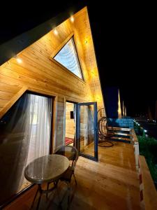 a house with a table and a window on a deck at A-Frame in Dolinka