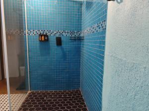 a blue tiled shower with a glass door at Serendipity Garden Studio Gateway to Kruger and Panorama Route in Kampersrus AH