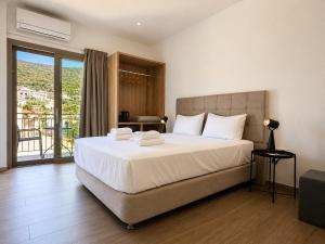 a bedroom with a large bed and a balcony at Dolphin hotel in Korfos