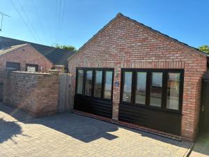 a brick house with a black garage at Griffin Lodge in Warwick