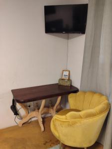 a desk and a chair with a television on a wall at Serendipity Garden Studio Gateway to Kruger and Panorama Route in Kampersrus AH