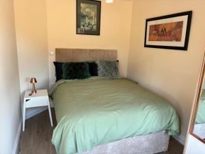 a bedroom with a bed with a green comforter at Griffin Lodge in Warwick