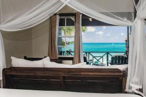 a bedroom with a bed with a view of the ocean at Keyonna Beach - All Inclusive - Couples Only in Saint Johnʼs
