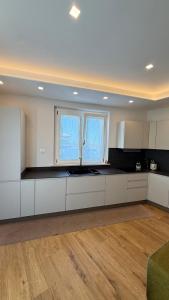 a kitchen with white cabinets and two windows at Villa Miranda RELAX in Ortona