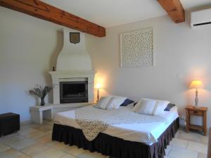 a bedroom with a bed and a fireplace at Clos des Lavandes - Chambres et Suites de charme climatisées-Luberon in Lacoste