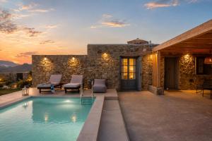 a swimming pool in front of a stone house at South Star private Mini Villa in Mikonos