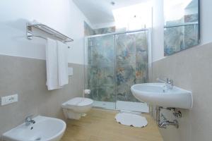 a bathroom with a toilet and a sink and a shower at Hotel Colorado in Rimini