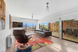 a living room with a couch and a chair at Riverview Townhouse Retreat in Lindisfarne