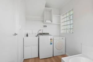 a white laundry room with two refrigerators and a sink at Riverview Townhouse Retreat in Lindisfarne +31 photos