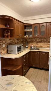 a kitchen with wooden cabinets and a microwave on a counter at Роман in Berehove