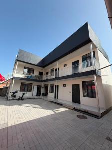 a large white building with a black roof at Aydin Guest House in Bayetovka