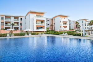 a swimming pool in front of some apartment buildings at Zephyr Mazagan in El Jadida