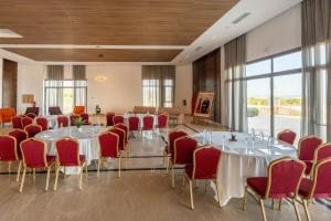 a conference room with tables and chairs and windows at Zephyr Mazagan in El Jadida