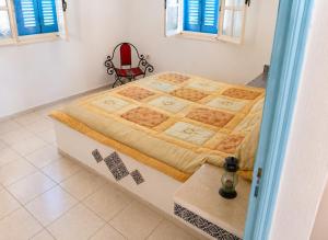 a large bed in a room with a red chair at Villa Jasmin Zarzis in Zarzis