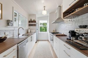 a kitchen with white cabinets and a sink at Riverbend Escape, Judbury in Judbury