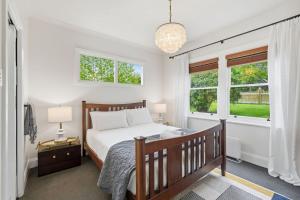 a bedroom with a bed and two windows at Riverbend Escape, Judbury in Judbury