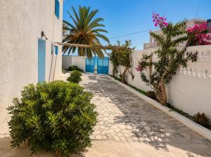 a cobblestone alley with trees and a white building at Villa Jasmin Zarzis in Zarzis